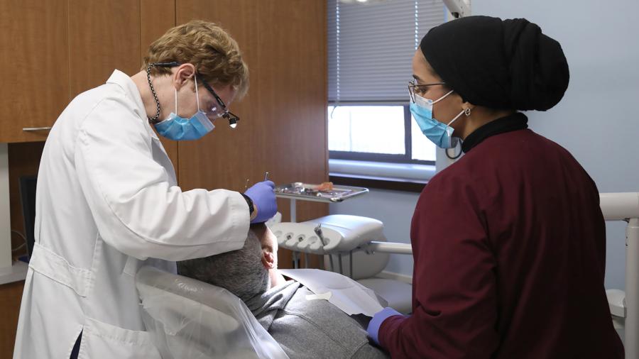 dentist and assistant cleaning a community patient's teeth